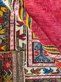 Underside view of antique wool area rug showing authentic natural dyes and geometric border art.