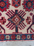 Hand-knotted Caucasian wool rug from circa 1880–1900 with a detailed floral chain border.