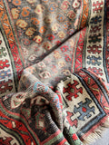 Small Caucasian area rug with traditional boteh design elements from the Caspian Sea region.