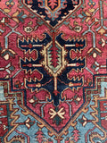 Close up of vintage Heriz carpet 7’ x 9’9 with bold tribal elements and striking color contrast throughout.