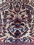 Vintage Persian Sarouk ivory area rug close-up of rose pink, camel, and French blue highlights woven into the flowers.