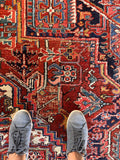 Antique handmade Persian Heriz carpet with scattered areas of wool wear and solid foundation.