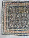 Dense weave antique Persian carpet top-down detail shot showing wool pile quality and soft wear patterns.