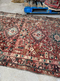 Long antique Persian runner rug with stacked medallions, teal accents, and compact wool pile.