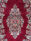 Authentic 1930s Persian Sarouk rug close up view of center floral medallion framed by soft ivory spandrels.