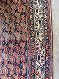 Antique Persian wool rug with shabby chic wear, repeating boteh motifs and handmade character.