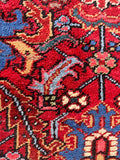 A handwoven tribal area rug crafted from vegetable-dyed red wool.