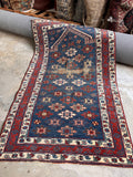 Antique Caucasian prayer rug featuring a deep blue ground and floral lattice design.