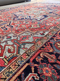 Hand knotted Persian area rug angled shot highlighting low pile texture and authentic timeworn character.