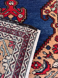 Long skinny Persian rug displaying weave texture.