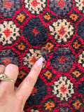 Hand knotted wool Persian tribal carpet close-up shot detailing minor authentic wool wear and characterful vintage patina.