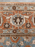 Antique Persian Tabriz rug border with terracotta floral motifs and finely woven traditional design.
