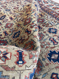 Handwoven Shirvan rug with warm neutral colors and tribal geometric artwork.