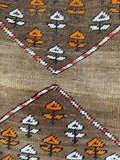 Close up of low pile antique runner with large diamond medallions and geometric floral motifs throughout.