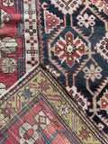 Underside view of tribal antique Caucasian rug with detailed lattice and border work.