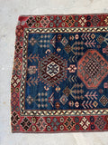 One end view of worn low pile Caucasian corridor rug with character and age.