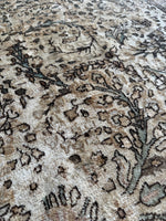 Close-up of curvilinear floral sprays on warm wheat background.