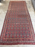 Long 16-foot Persian rug with intricate allover design on a navy blue ground.