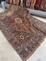 Nomadic Shiraz rug handwoven with vegetable-dyed wool in earthy tones.
