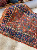 Vintage Persian rug with botanical pattern continuation.