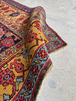 Linked paisley motifs on saffron yellow border of Bidjar rug.