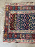 One end view of color changing Persian runner showing navy to brown ground variation.
