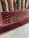 Antique Persian Yomut bag face rug showing deep red pile and intricate geometric tribal göl design.