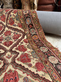 Persian Bakhtiari rug flat-lay detail showcasing repeating diamond lattice on off-white wool.