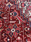 Oversized Persian Heriz carpet with navy, coral, teal, and ivory tones throughout.