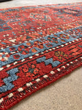Rustic northwest Persian runner angled to display the durable flat weave and rich indigo-and-orange contrast.