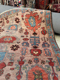 Corner detail of Heriz rug showing floral border and motifs.