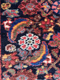 Periwinkle and coral Herati runner detailed photo showcasing the pops of blue and coral against the dark background.