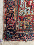 Corner view of antique Heriz rug 7’ x 9’9 featuring sky blue field and deep watermelon hues with natural abrash variation.
