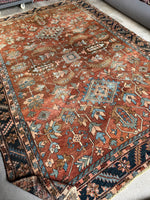 Antique Persian Heriz rug with terracotta and burnt sienna tones