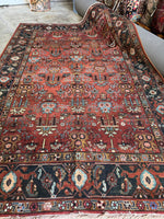 Full view of antique Persian Heriz with wild botanical motif arrangement.