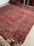 Handwoven Persian rug featuring berry red background