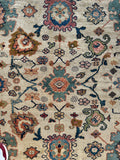 Timeless vintage rug with ivory background and colorful patterns.
