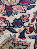 Close-up of the tight, hand-knotted weave and finely drawn petals and stems.