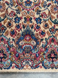 Close up view of long narrow runner 21 ft 5 in x 35 in with dusty rose accents and scrolling vine pattern.