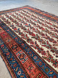 Vintage rug with ocean blue botanical border accents.