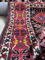 Abstract crab design in main border band on red background.