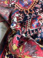 Edge of Kazak rug with visible vegetable dyed wool fibers.
