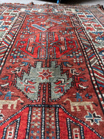 Antique Kazak runner showing animal and human woven motifs.