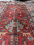 Antique Kazak runner showing animal and human woven motifs.