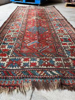 Kazak runner framed by whimsical strips flanking the main border.
