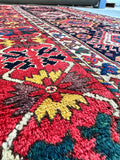 Close-up of intricate border motifs in red, ivory, and yellow.