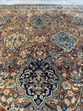 Close-up of Kerman rug showing soft ivory and layered blue motifs.