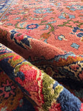 Antique coral Persian rug 9x12 with historic German provenance laid out flat to show full pattern.