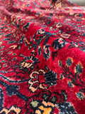 Ruby red Lilihan rug with poetic allover floral motifs.