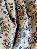 Antique rug with stunning paisley borders and floral details.